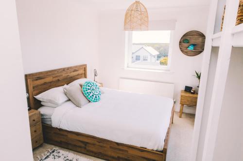a bedroom with a bed and a window at Pentire Point - Fully Equipped Eco Escape in Crantock