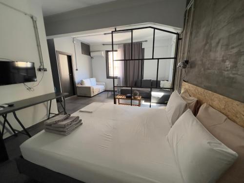 a bedroom with a white bed and a living room at Virginia's Boutique Apartments in Athens