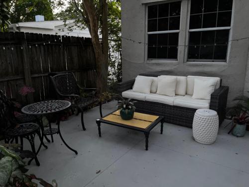 a couch on a patio with a table and chairs at Hollingsworth Guest House With Pool in Lakeland