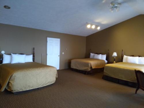 a hotel room with two beds and a door at Beach House Lakeside Cottages in Mackinaw City