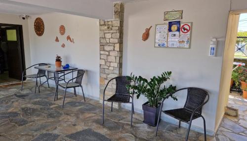 stół i krzesła w pokoju z rośliną w obiekcie Studios Achileus w mieście AgiaKampos