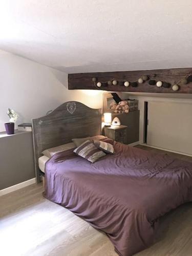 - une chambre avec un grand lit violet et 2 oreillers dans l'établissement Charmante maison T2 au Centre de Bordeaux, à Bordeaux
