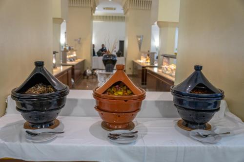 three vases sitting on a table with spoons at Hotel Andalucia Tangier in Tangier
