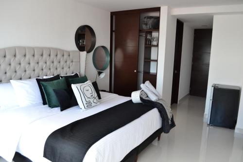 a bedroom with a large bed with black and white pillows at Estudio Neen Zona Hotelera in Cancún