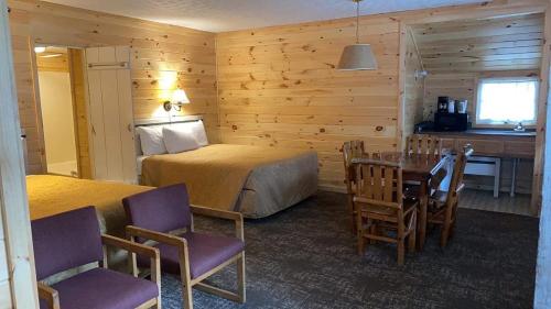 a bedroom with a bed and a table and chairs at Beach House Lakeside Cottages in Mackinaw City