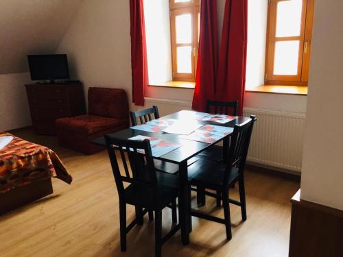 una mesa de comedor y sillas en una habitación con ventanas en Villa Luef en Mönichkirchen