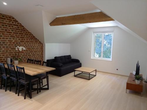 un salon avec une table et un canapé dans l'établissement L'orangerie de Nesle bis, à Nesle