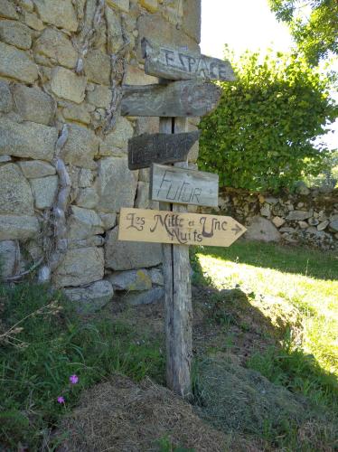 a directional sign in front of a stone wall at Voyage Spatio-Temporel in Poussanges