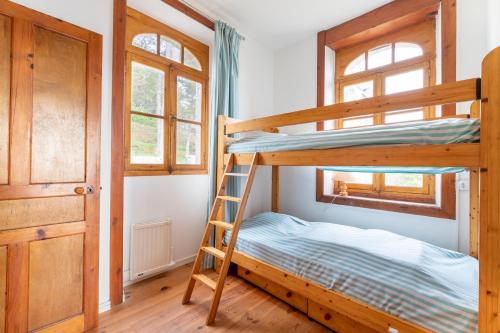 Un dormitorio con dos literas y una escalera. en Vue imprenable sur la mer pour 7 pers à Pléneuf, en Pléneuf-Val-André