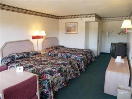 a hotel room with two beds and a tv at El Dorado Inn Suites - Nogales in Nogales