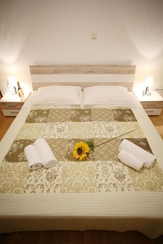 a bed with two pillows and a sunflower on it at Holiday house Poljana in Poljana