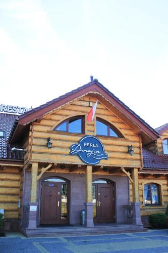 a log building with a sign on it at Perła Dunajca Zakliczyn in Zakliczyn