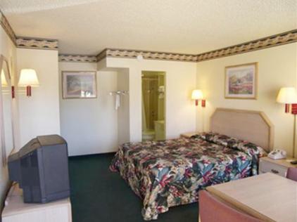 a hotel room with a bed in a room at El Dorado Inn Suites - Nogales in Nogales