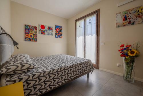 a bedroom with a bed and a vase of flowers at Casa Bella in Argegno