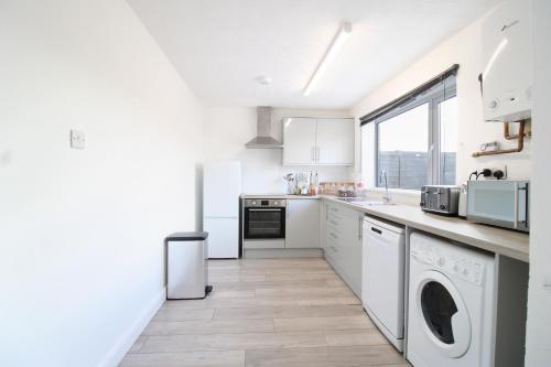 a white kitchen with a washer and dryer at Virexxa Aylesbury Centre - Deluxe Suite - 3Bed House with Free Parking in Aylesbury