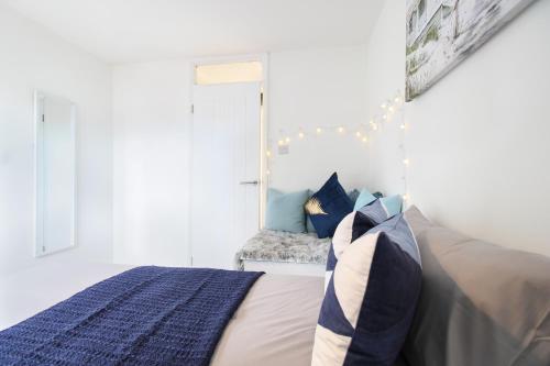 a bedroom with a bed and a window with lights at Virexxa Aylesbury Centre - Deluxe Suite - 3Bed House with Free Parking in Aylesbury