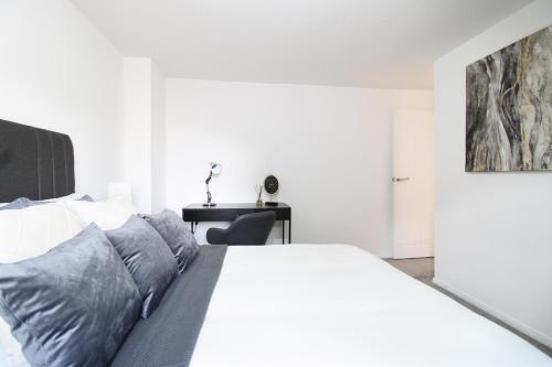 una camera con letto bianco e scrivania di Virexxa Aylesbury Centre - Deluxe Suite - 3Bed House with Free Parking ad Aylesbury