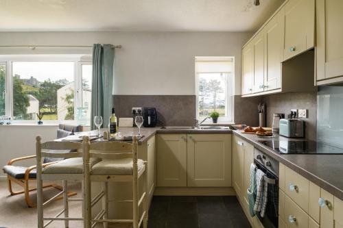 a kitchen with a table and some chairs in it at Finest Retreats - Golygfa o'r Castell - Castle Views in Harlech