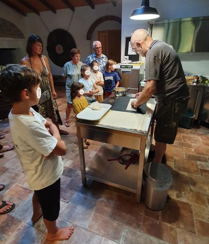 a group of people standing around a table in a kitchen at Corte Attilea in Valeggio sul Mincio