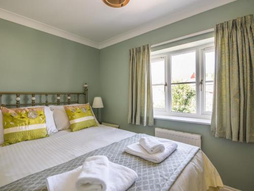 a bedroom with a bed with towels on it at Seagull Cottage in Lyme Regis