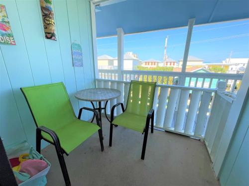 a balcony with a table and two chairs and a table at LIVE ON ISLAND TIME! GREAT GULF SHORES BEACH CONDO, VERY NICE in Gulf Shores