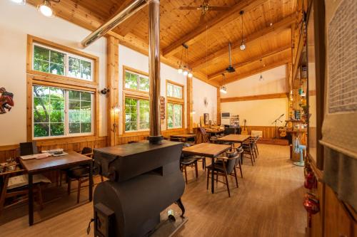a restaurant with tables and chairs and a piano at Healing Camp Yesone in Gangneung