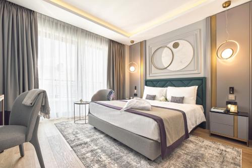 a bedroom with a large bed and a chair at La Fleur Boutique Hotel in Tivat