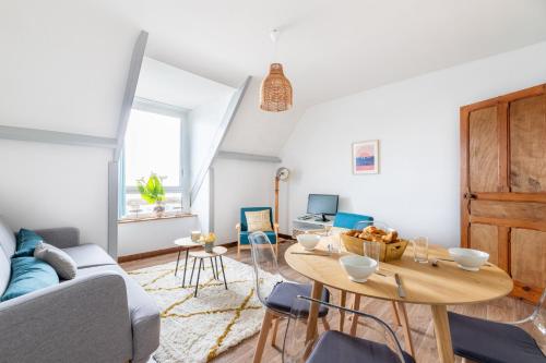un salon avec une table et un canapé dans l'établissement Maison de famille pour 15 - 1km de la plage, à Pléneuf-Val-André
