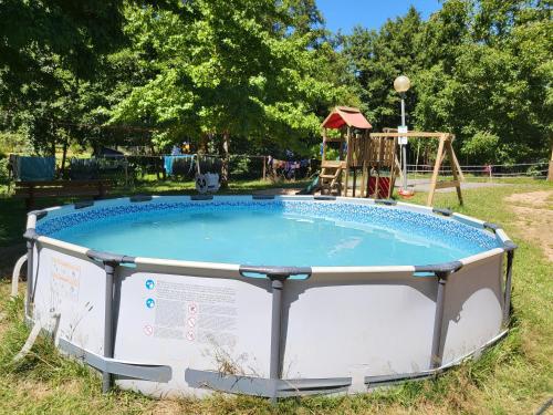 a small pool with a playground in the grass at L'alternatif in Huriel