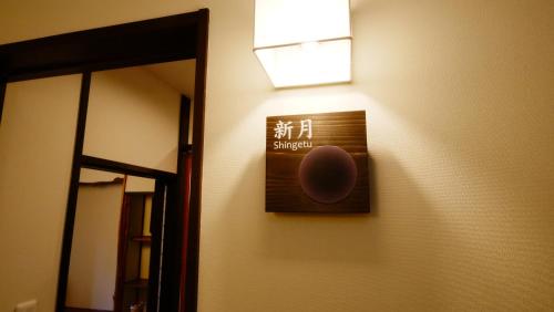 a sign on a wall next to a mirror at Oyado Tsukiusagi in Miyajima