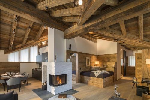 a living room with wooden ceilings and a fireplace at Chalet Residences Mathon in Ischgl