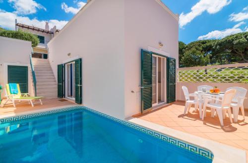 a villa with a swimming pool and a patio at Oceans 8. in Almancil