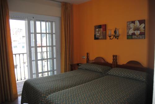 a bedroom with a bed and a large window at Hostal Italia in Fuengirola