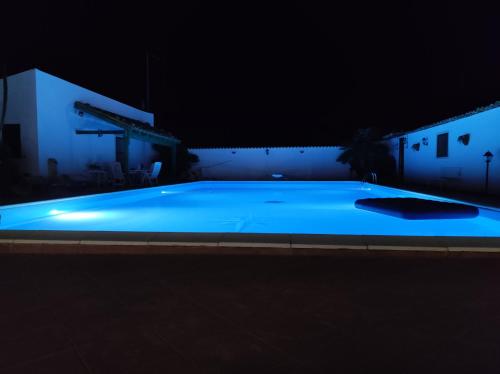 a large blue swimming pool at night at il Cigno Reale-Green-Rooms Leasing Touristic Ragusa in Chiaramonte Gulfi