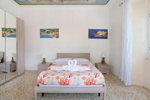 a white bedroom with a bed with a white bow on it at Acciuga House in Biassa