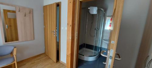 uma casa de banho com um chuveiro e uma porta de vidro em Pokoje Gościnne Maczek em Sztutowo