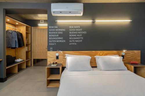 a bedroom with a bed and a wall with words on it at Intercity Canoas in Canoas
