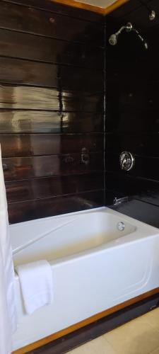 a bath tub in a bathroom with a black wall at Meares Vista Inn in Tofino