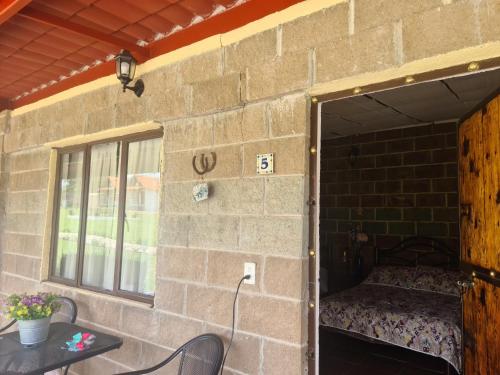 a room with a bed in a brick wall at Finca Los Angeles Hospederia & Sociales in Huasca de Ocampo