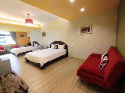 a bedroom with two beds and a red couch at Mamamia Homestay in Hengchun