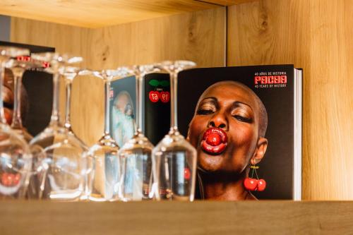 a shelf with wine glasses and a picture of a black woman at Pacha Hotel in Ibiza Town