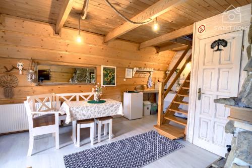 a dining room with a table and a staircase in a cabin at Oaza Tatry I in Zakopane
