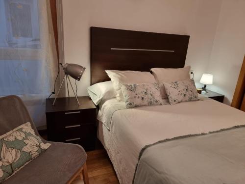 1 dormitorio con cama, lámpara y silla en Apartamento ria de Viveiro, en Viveiro