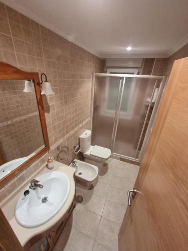 a bathroom with a sink and a toilet and a shower at Apartamento ria de Viveiro in Viveiro