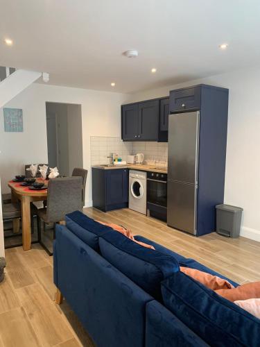 ein Wohnzimmer mit einem blauen Sofa und einer Küche in der Unterkunft 13 Eyre Square Lane in Galway