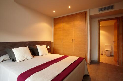 a bedroom with a large bed with a wooden headboard at Apartaments Terraza Figueres in Figueres