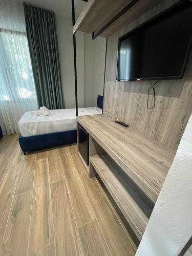 a hotel room with a bed and a flat screen tv at Gogo's Boutique Hotel in Dhërmi