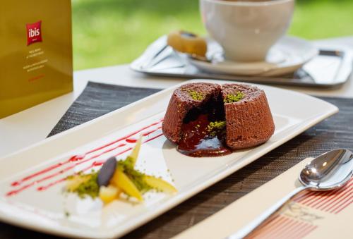 a plate with a piece of cake and a cup of coffee at ibis Ankara Airport Hotel in Ankara