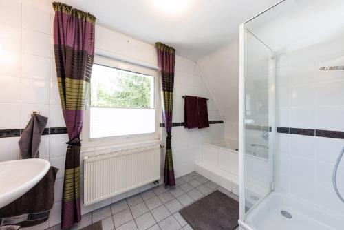 a bathroom with a tub and a sink and a shower at Ferienwohnung Roth in Hilchenbach