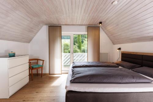 a bedroom with a large bed with a wooden ceiling at Ferienwohnung Roth in Hilchenbach